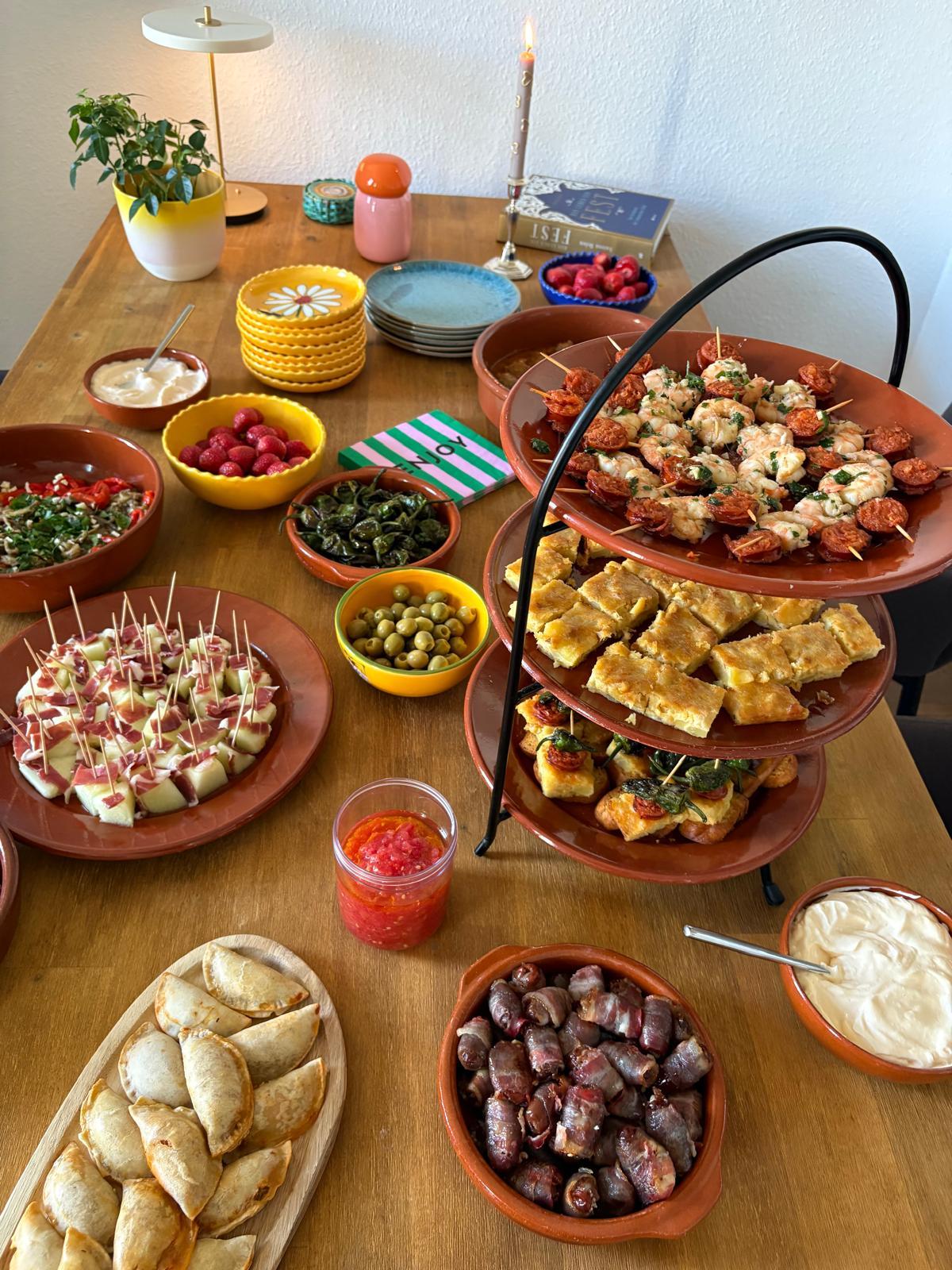 Gedeckter Tisch mit Jamón-Melonen-Spießen und speckummantelten Datteln