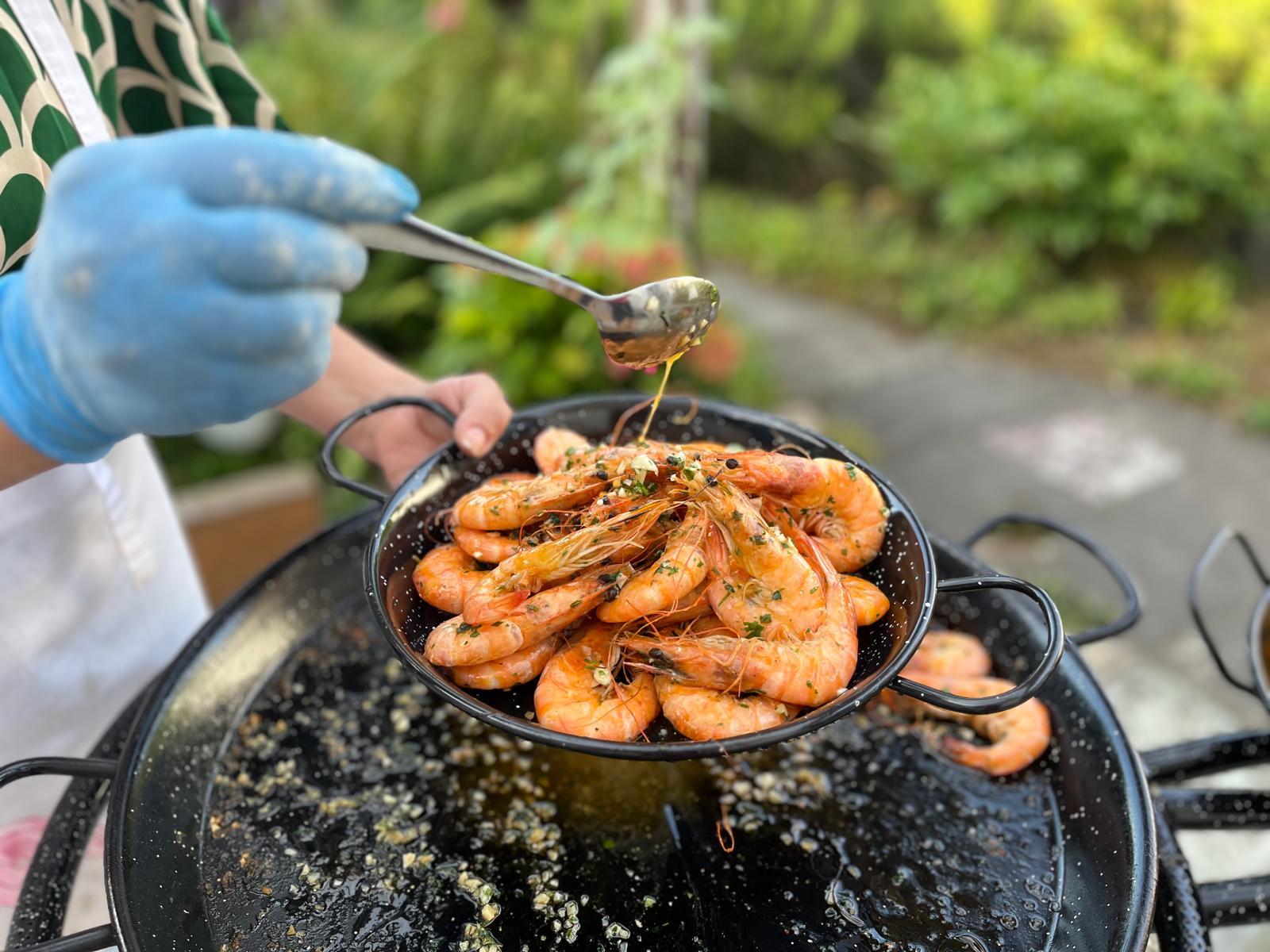 Garnelen werden mit einer aromatischen Sauce beträufelt