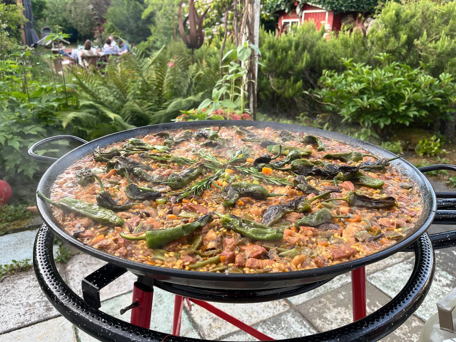 Fertig gegarte Paella mit Pimientos im Garten