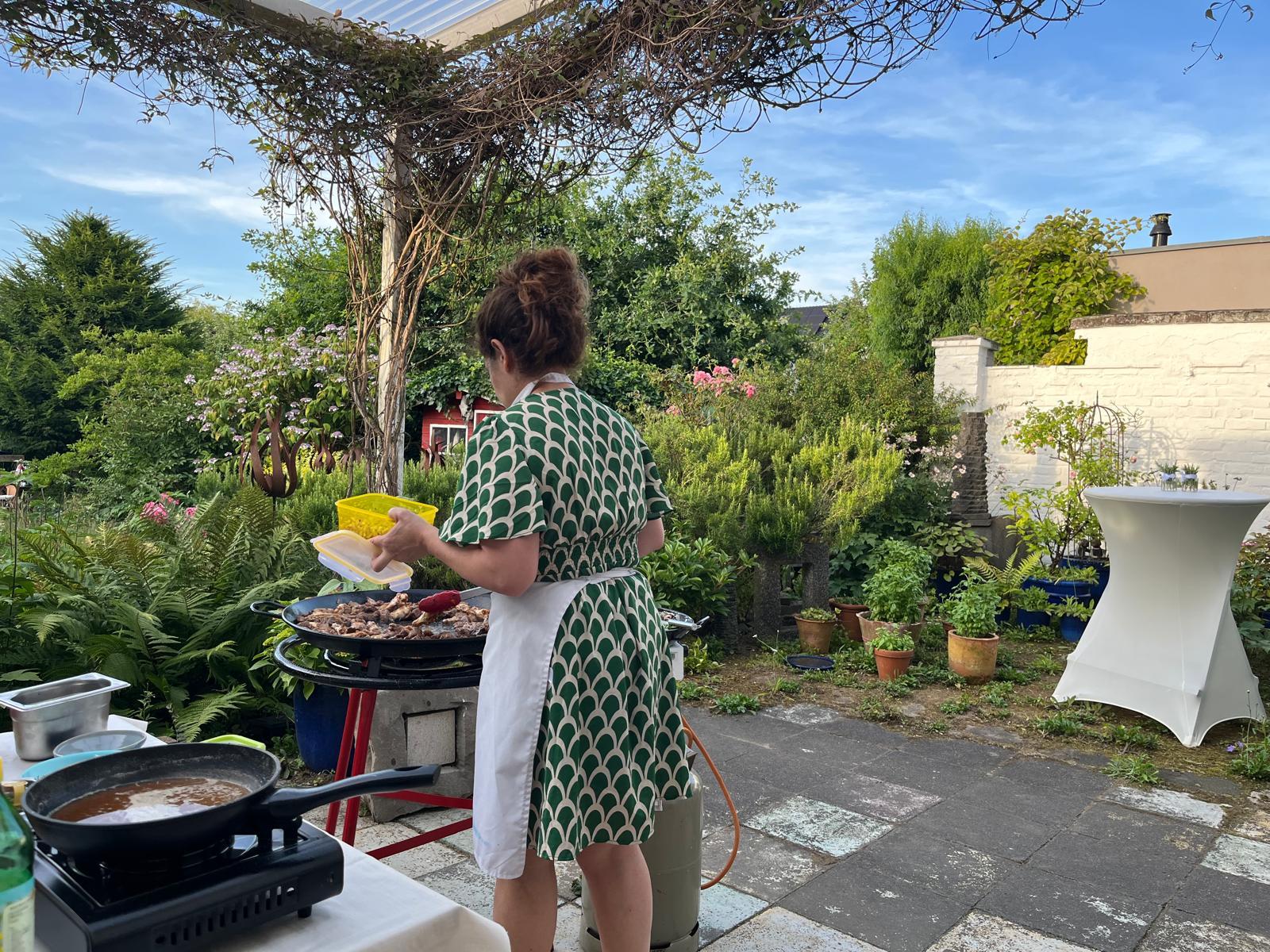 Julia Sanchez rührt die Paella-Pfanne im Garten an